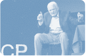 Bob Davis. A mature man, former entrepreneur. Sitting on a chair during TED speech in Paris, gesturing to the audience.